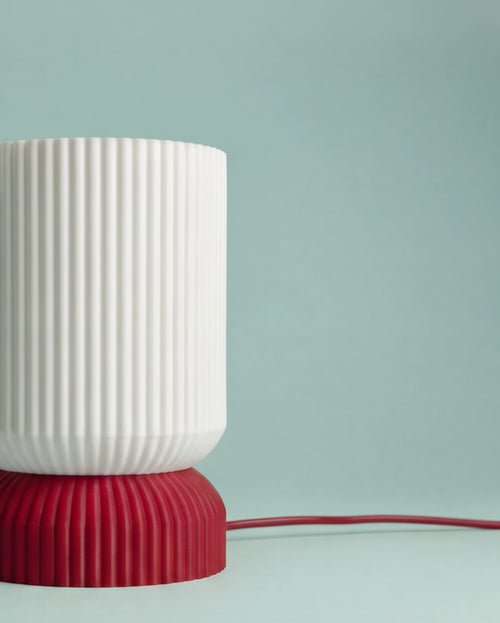 Close-up of the Luma lamp shade and ribbed red base