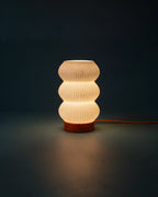 Soma table lamp lit at night on a side table