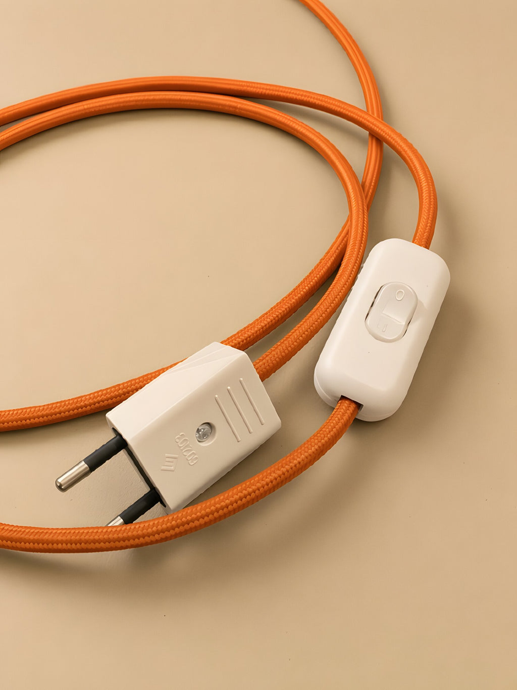 Nubo in Orange: the white switch and the plug on the braided cable
