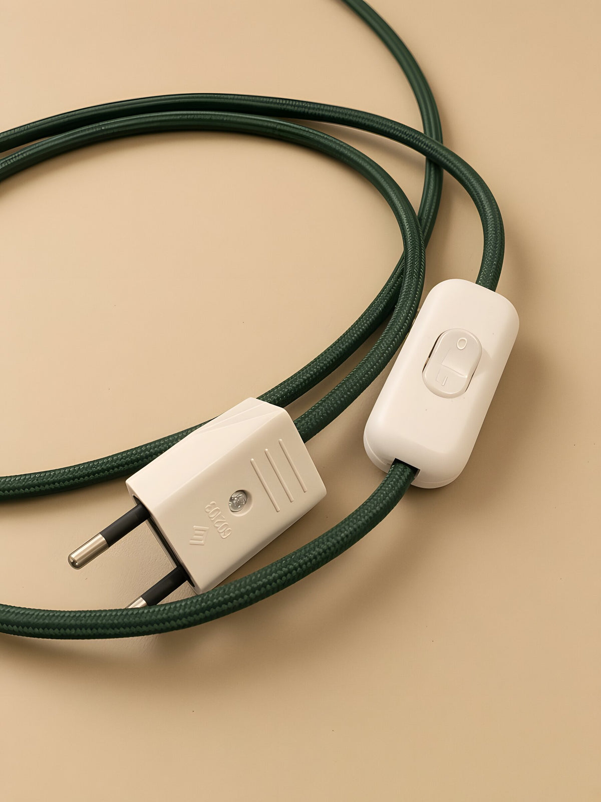 Nubo in Green: the white switch and the plug on the braided cable